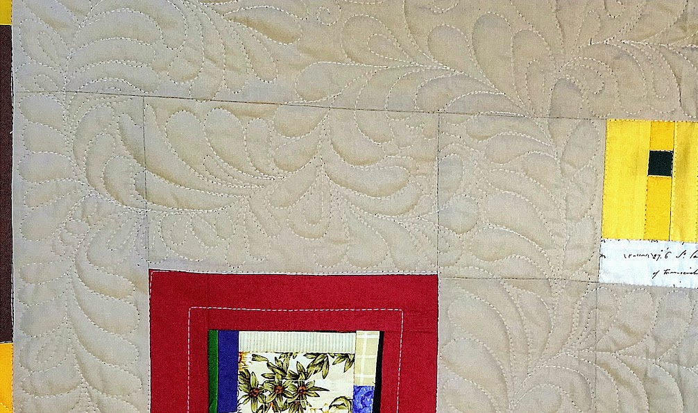 color photo showing the feather work quilting on the tan background of a quilt