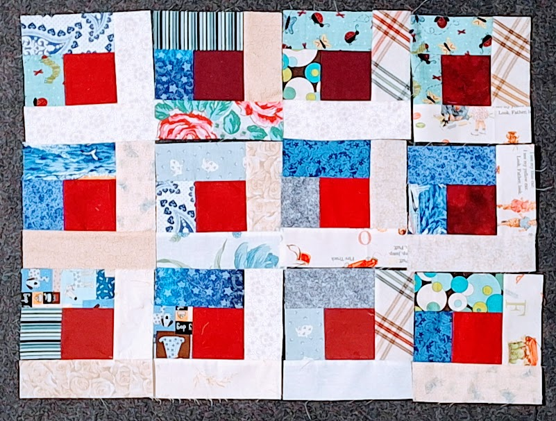 the beginning of blue and white log cabin blocks with red centers