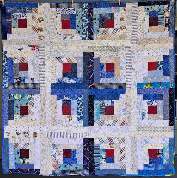 Photo of completed log cabin quilt in white and blue. Emmy Blue's Quilt; Mary Marcotte; 2025; 51" X 51"; Inspired by the book The Quilt Walk by Sandra Dallas