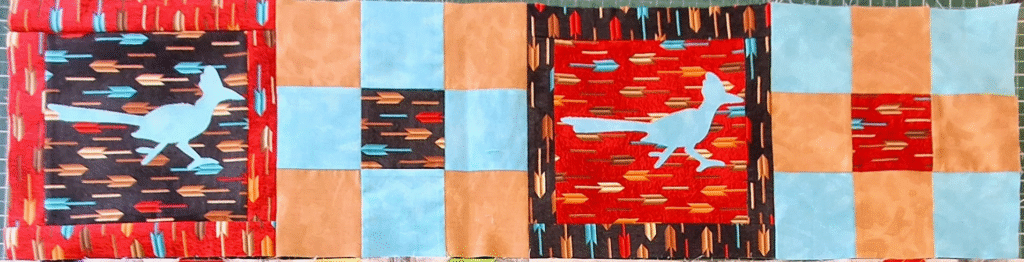 This photo and the two following it are long narrow strips of blocks that represent something near the quilt shop that created it for a universal shop hop in 2019.