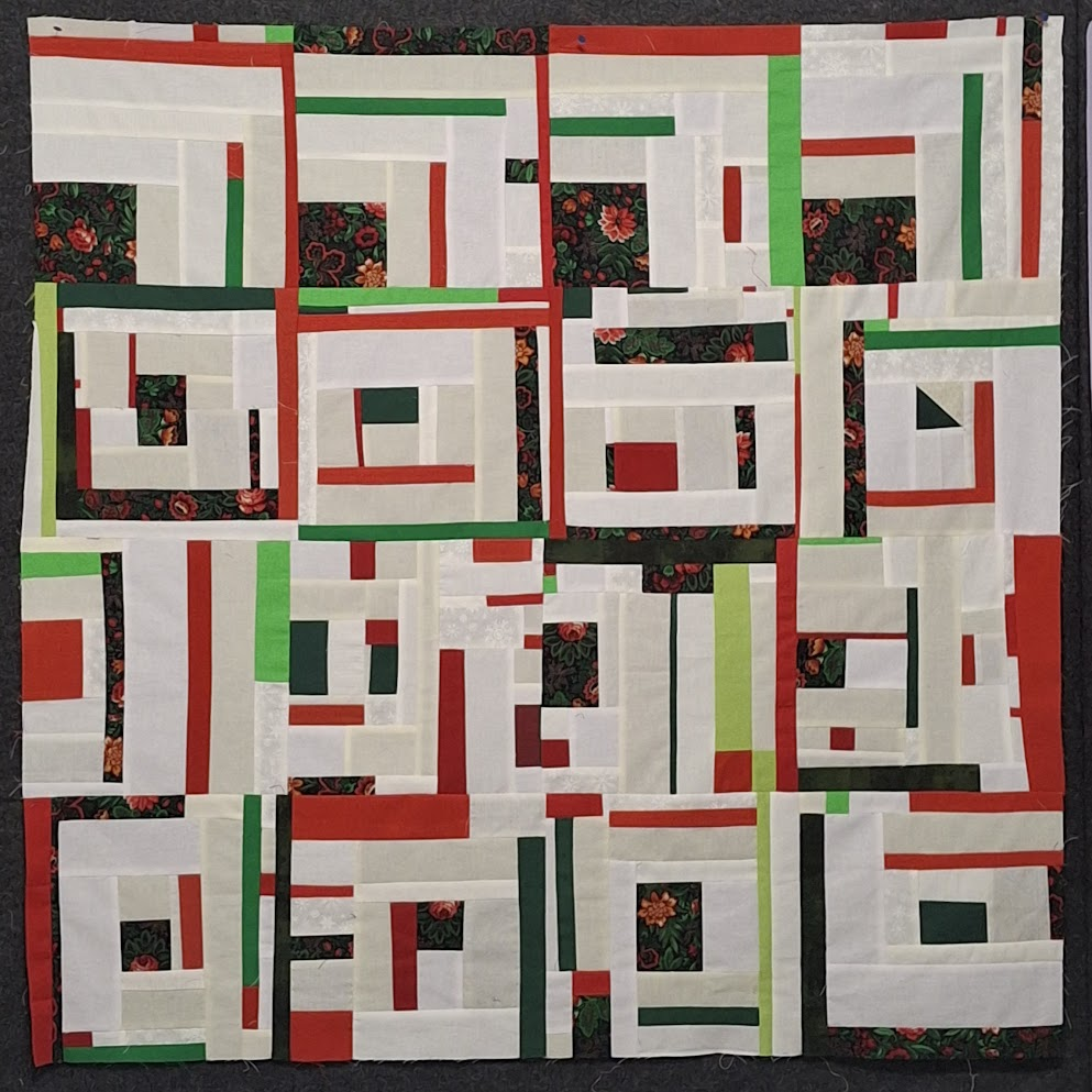 A completed improv log cabin quilt top, or flimsy.