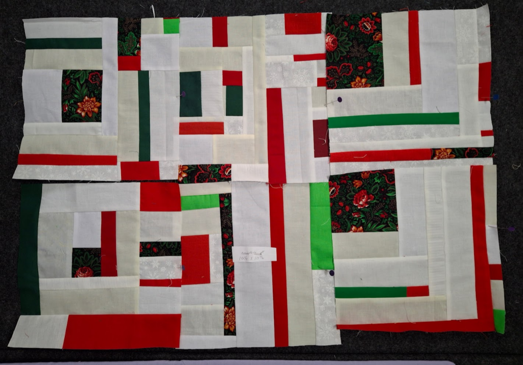 Six complete improv log cabin blocks in a variety of reds, greens, and whites.