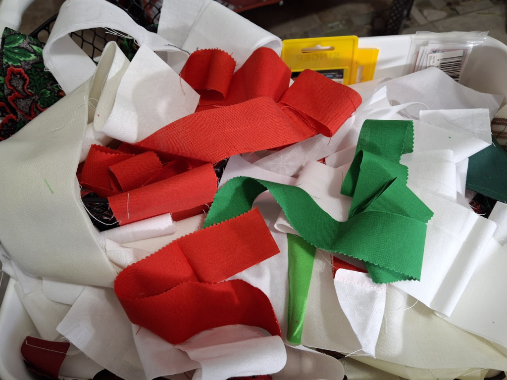 A photo of red, green, and white fabric strips waiting for their respective blocks.